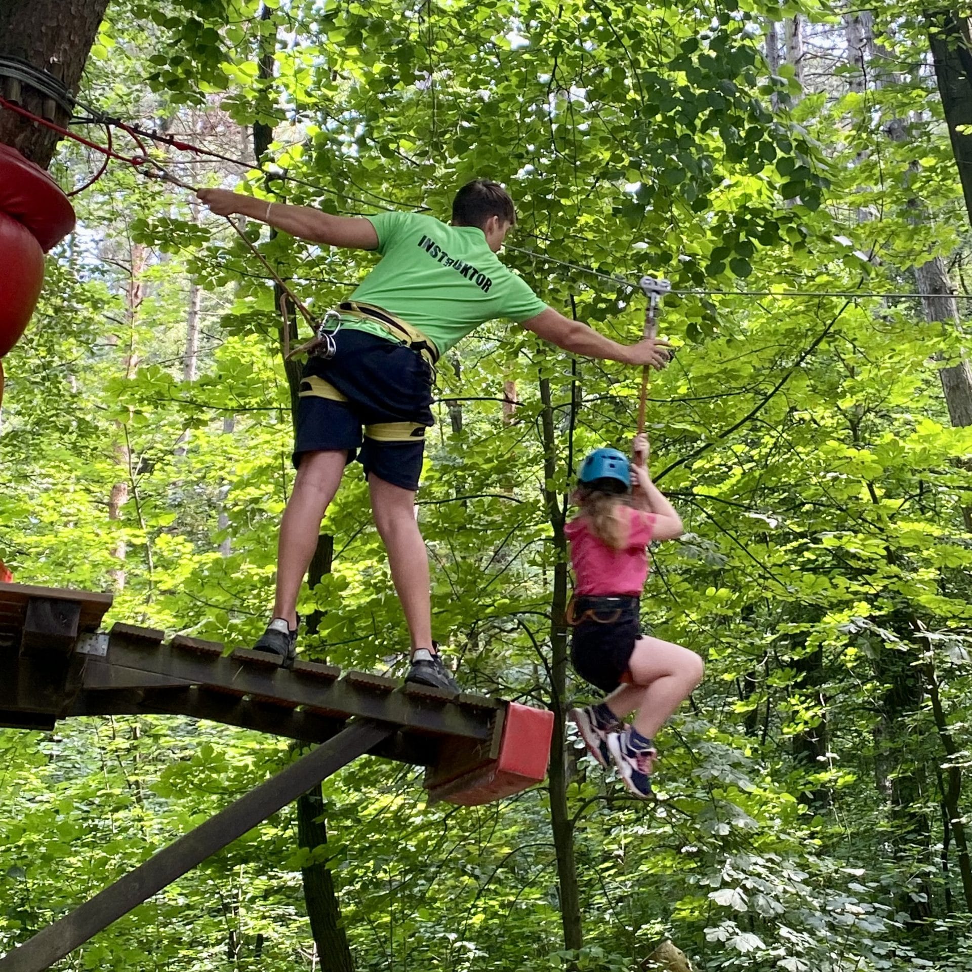 Instruktor asekurujący dziecko na trasie w Xtreme Park Wieliczka